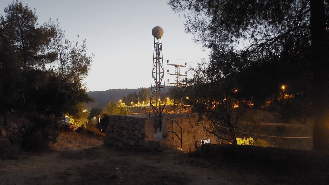 Hillel Roman, Providence, 2024, observation tower, stone hut, cctv camera and projector, Ananeh art center
